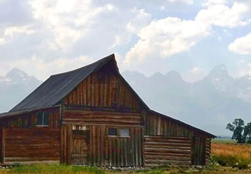 Old barn in front of tall mountains