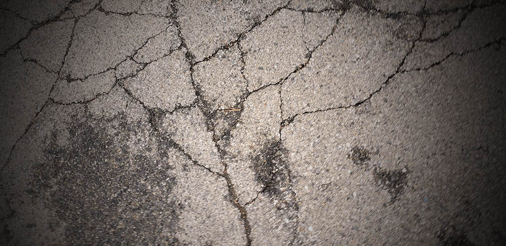 faded and craked blacktop road surface.